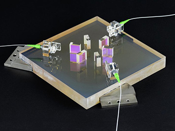photo of optical bench with lasers coming through fiber