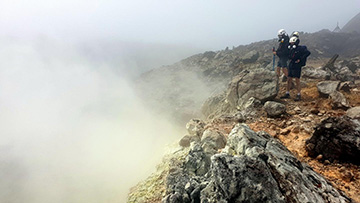 photo of researcher at edge of volcano