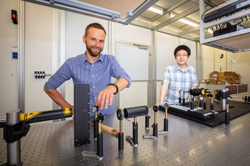 Photo of researchers in front of optical bench