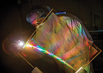 Man working on optical glass element